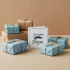 KOULEURS branded kraft gift box with black foil logo, styled for clothing gifts like t-shirts or sweatshirts