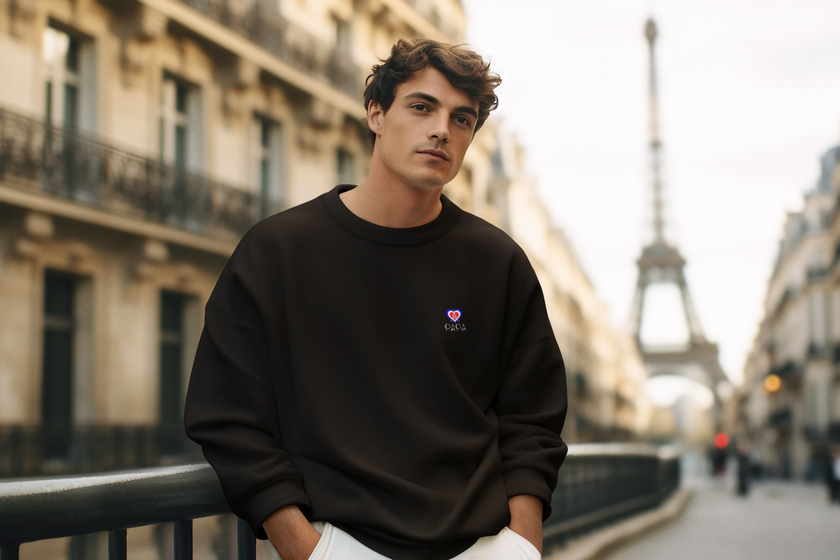 Model wearing KOULEURS men’s black sweatshirt with Eiffel Tower and pink “Papa” lettering, designed for Father's Day.